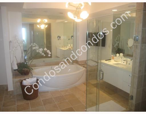 Master bath contains Jacuzzi whirlpool tub and glass shower