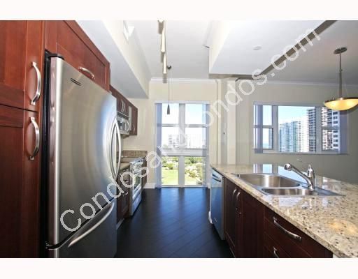 Kitchen with designer light fixtures and open city view