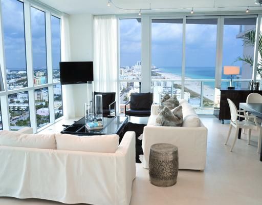 Living area with views of ocean, beach and city