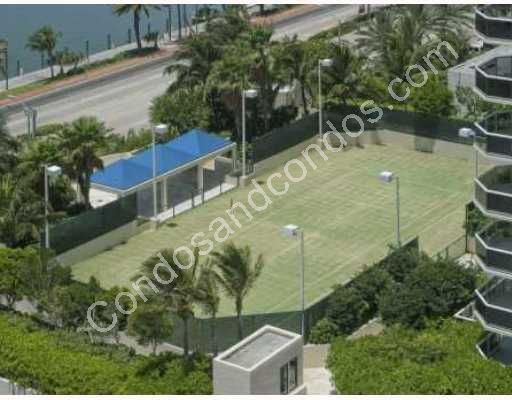 Two lighted tennis courts with a landscaped promenade