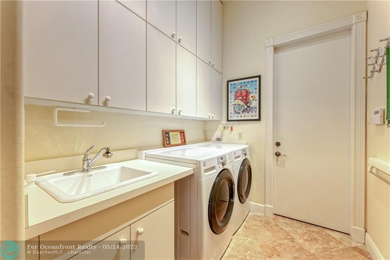 Large laundry room with front loading washer and dryer and tons of cabinet space