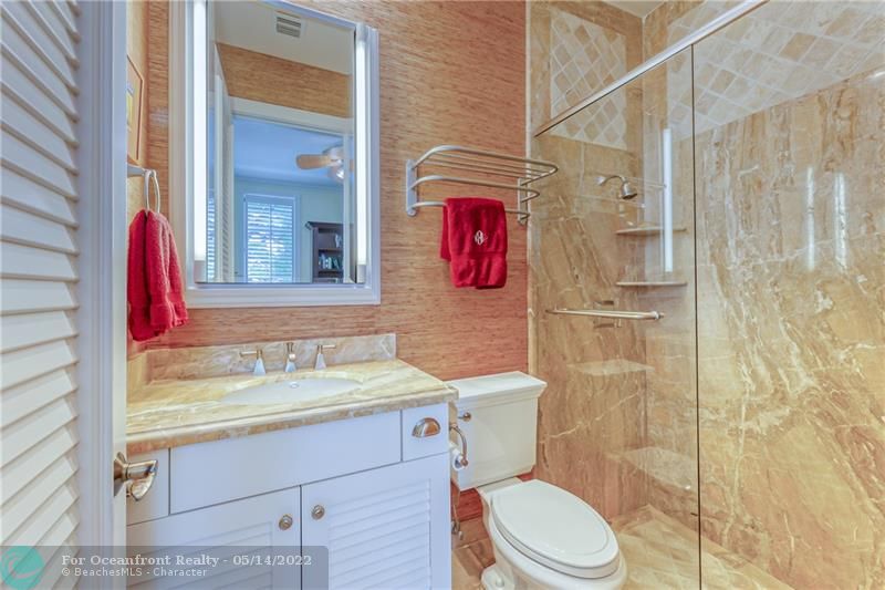 Bathroom with walk in shower and grass cloth wallpaper