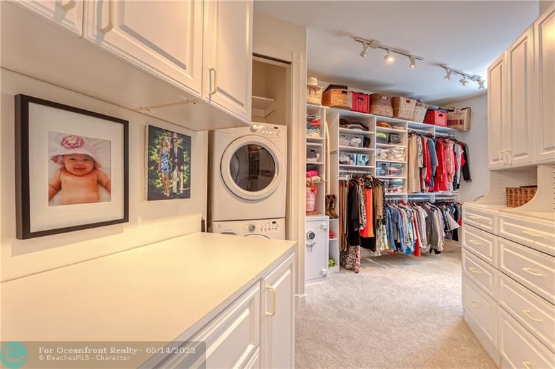 Master closet with tons of built ins and washer and dryer