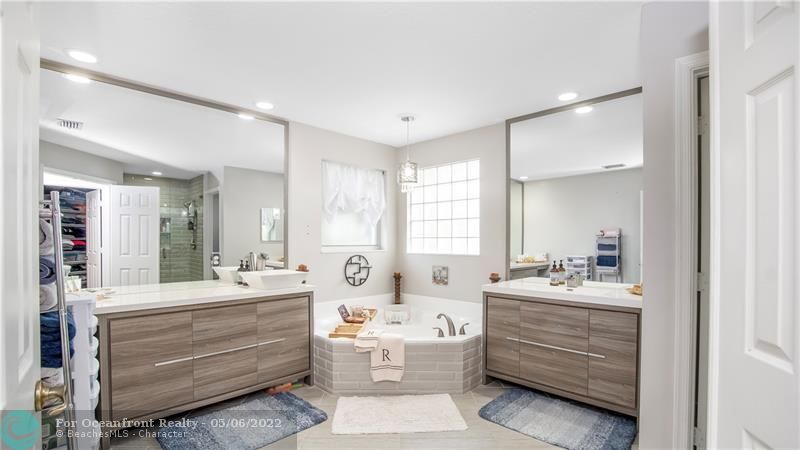 Elegant primary bathroom with separate vanities and sinks.