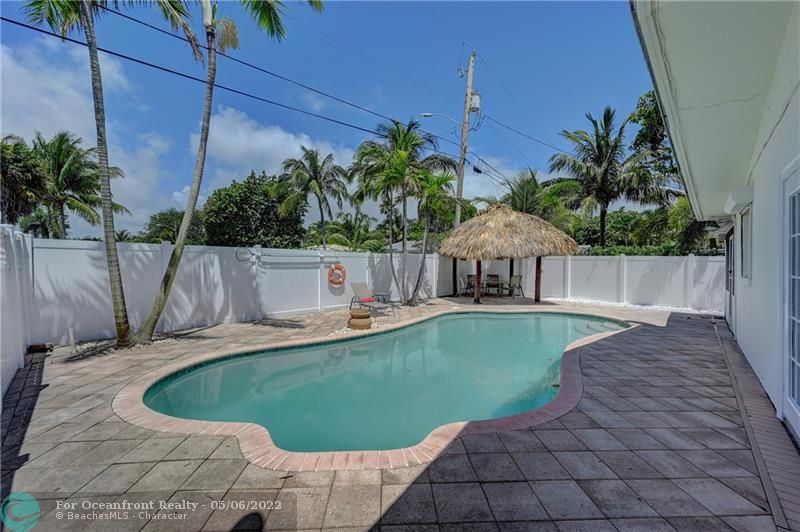 Private backyard features freeform salt water pool, tiki hut, screened Lanai, and fire pit area!